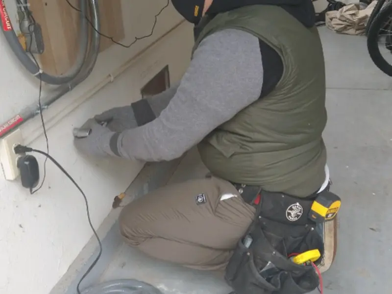Electrician performing outlet wiring in a South Fayette garage